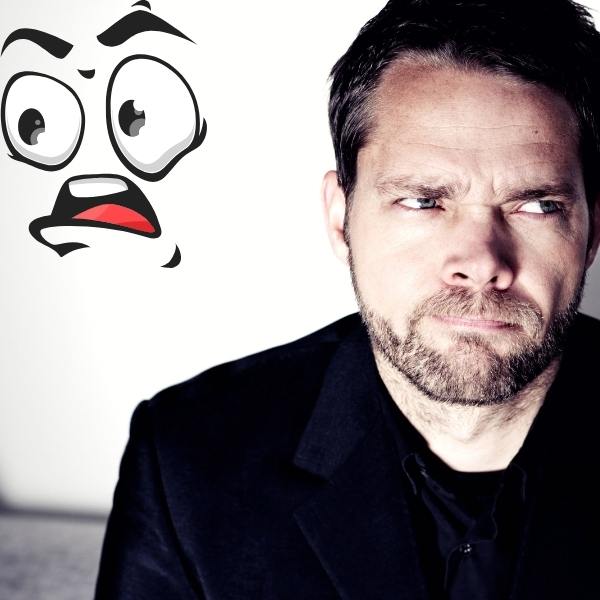 the grumpy sunshine romance trope. Man in black shirt and grumpy face