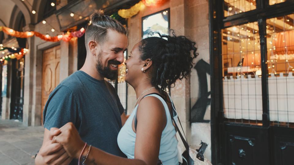 white man and black woman in love looking at each other, hands clasped